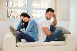 41099799 - portrait of a displeased couple sitting back to back on couch