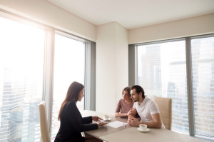 Young couple and real estate agent manager discussing contract a